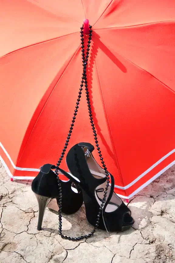 A set of stilettos with a red umbrella